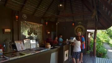 A reception area with a wooden ceiling, a reception desk, and a view of the outdoors.
