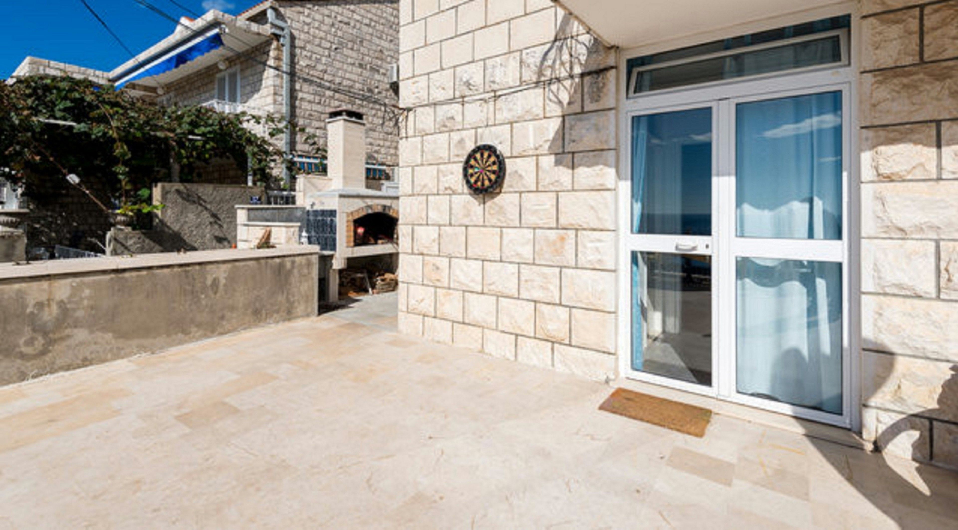 A building with a stone facade, a dartboard, and a glass door.