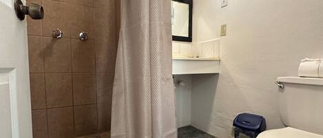 Un baño con ducha, inodoro y lavamanos.