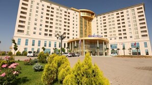 Un grand hôtel doté d’une entrée principale, de plusieurs étages et d’un jardin bien entretenu.