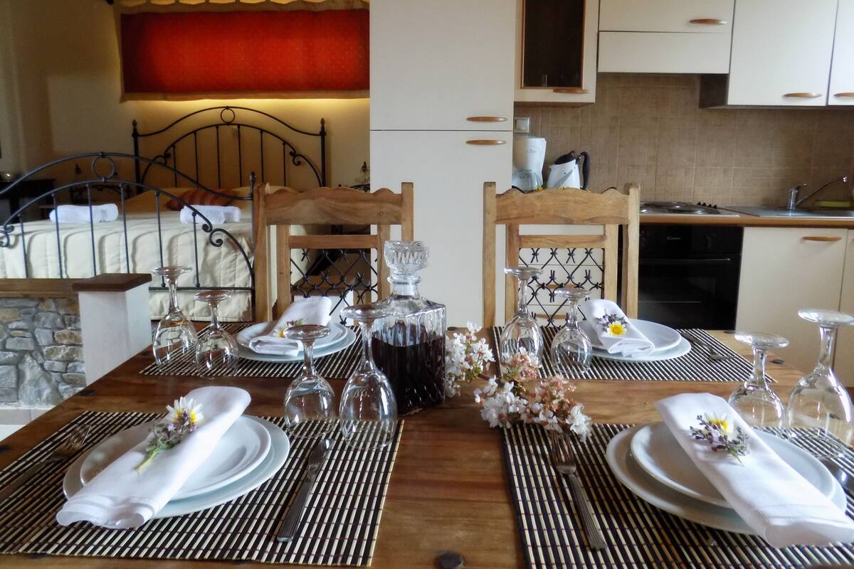Een eettafel met borden, bestek en wijnglazen, omringd door stoelen.