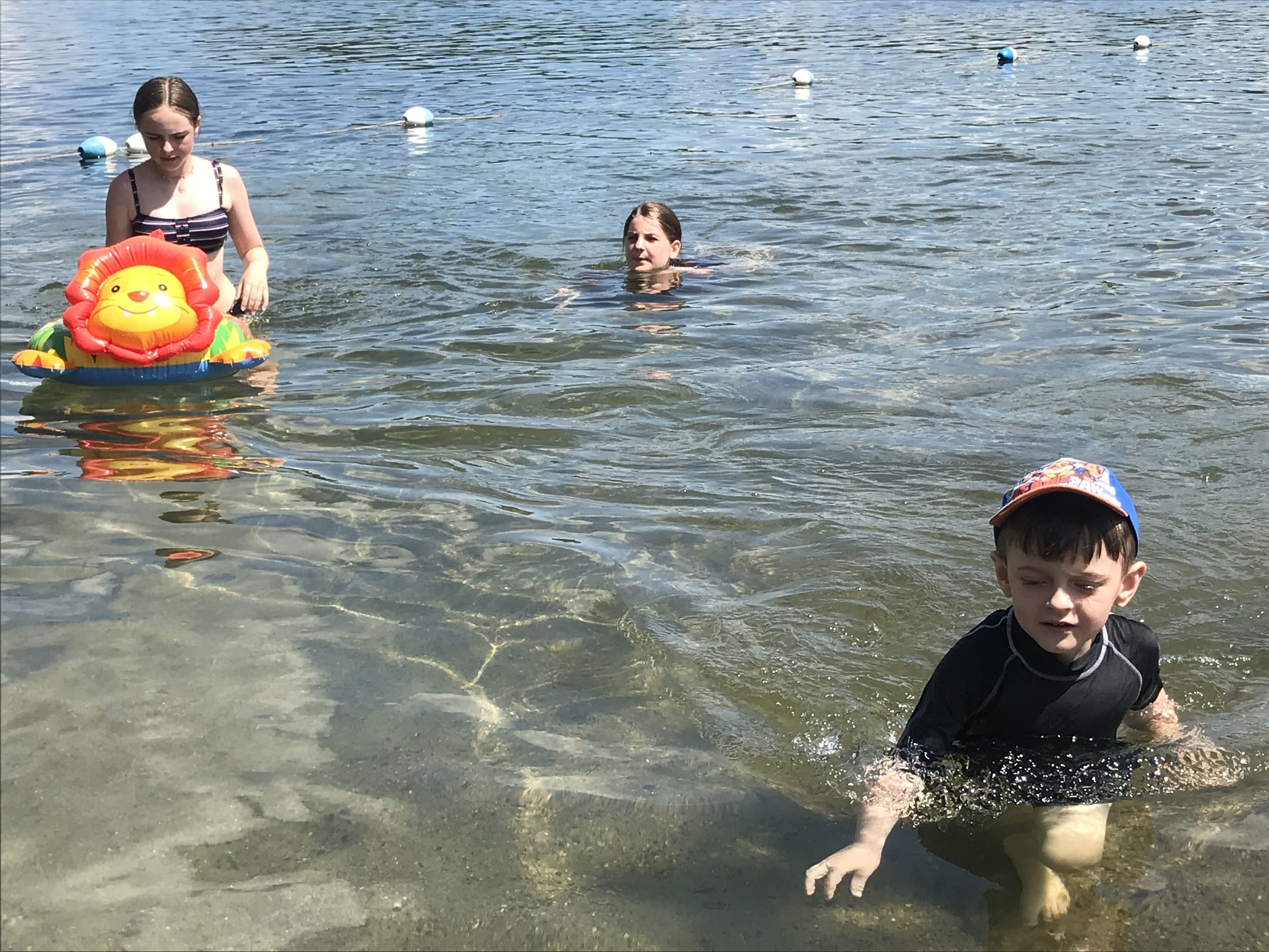 Helder waterlichaam met mensen die zwemmen en drijven.