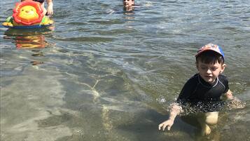 Helder waterlichaam met mensen die zwemmen en drijven.