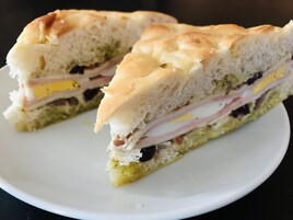 Un sándwich cortado por la mitad sobre un plato blanco.