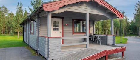 A small cabin with a porch, a door marked '62', and a wheelchair ramp.
