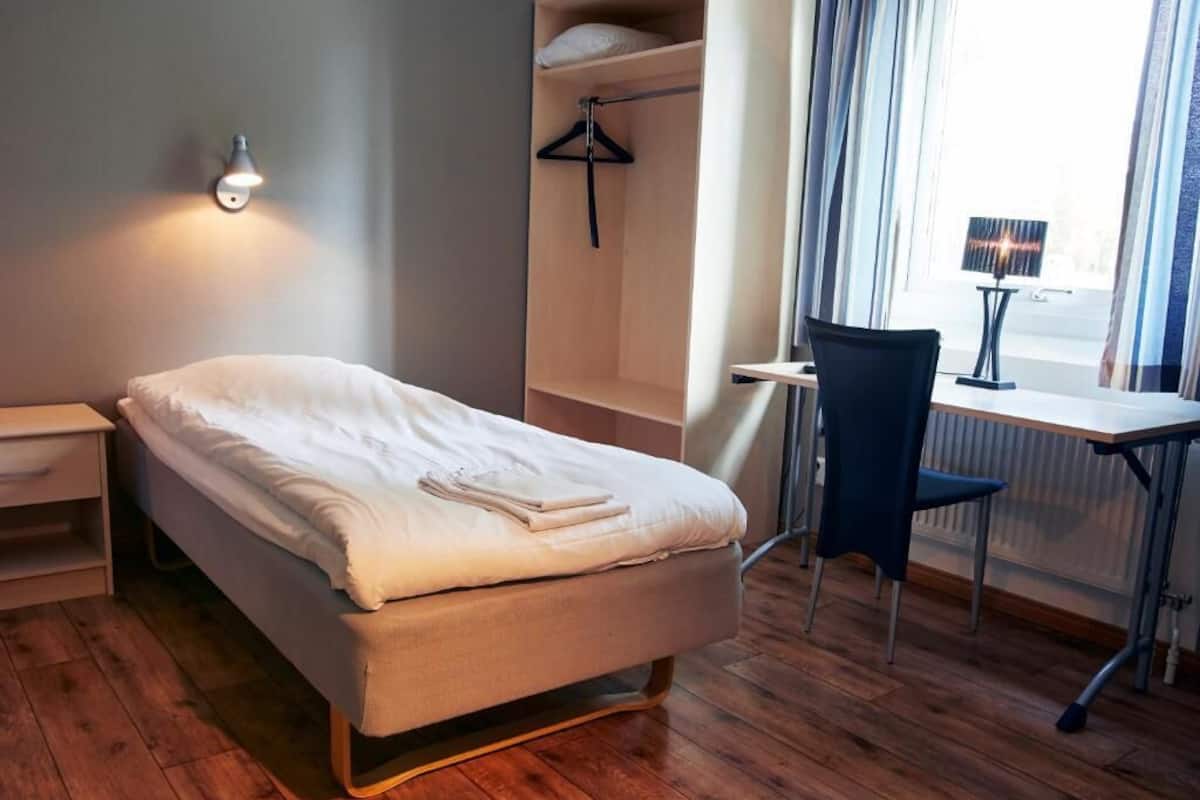 Une chambre à coucher avec un lit, un bureau et une chaise.