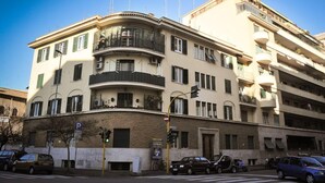 A multi-story building with balconies, a parking sign, and a pedestrian crossing. - Camere del Cavaliere (Rome)