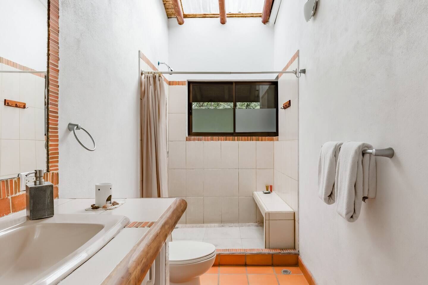 A compact bathroom with a bathtub, toilet, and shower area.
