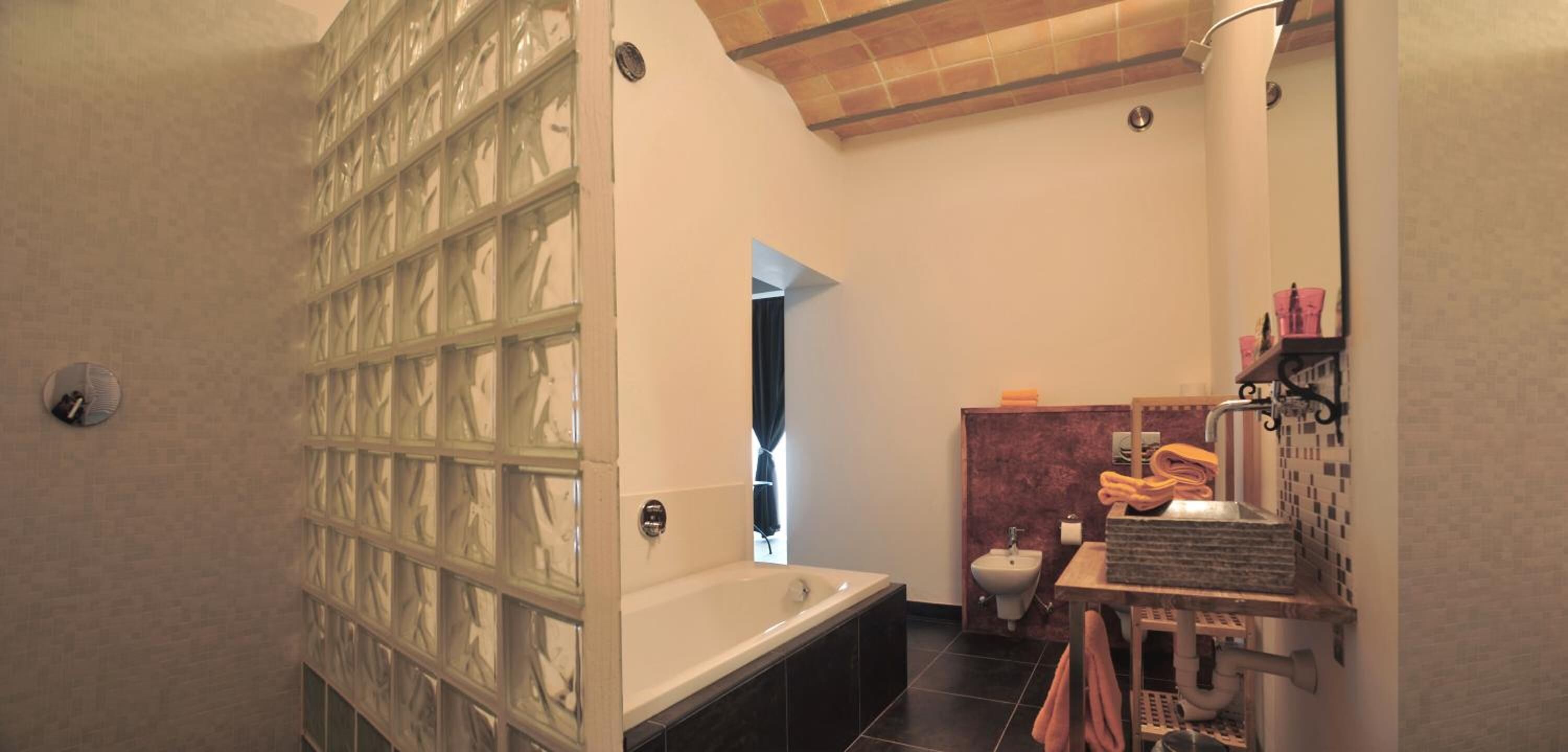 Un baño con bañera, cabina de ducha, lavamanos con espejo e inodoro.