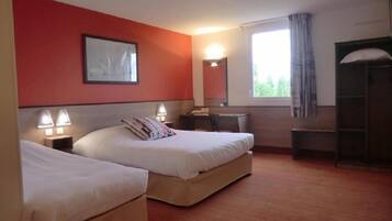 A hotel room with two beds, a desk, a chair, a window with curtains, a mirror, and a wall-mounted picture.