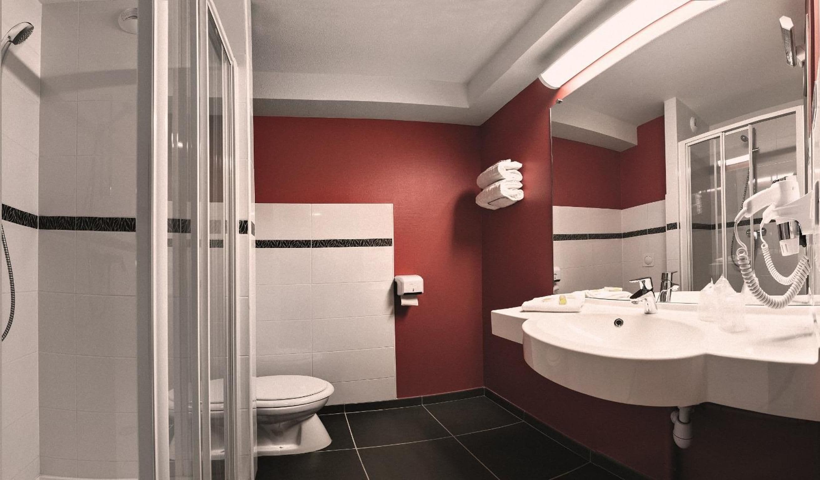 Un baño con inodoro, lavamanos y ducha.