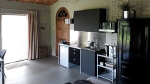 A modern kitchen with a wooden ceiling, a built-in oven, and a black cabinet. - Studio Verhuur Jamzes (Hoogerheide)
