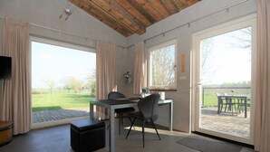 A modern room with a large window, a desk, and a chair. - Studio Verhuur Jamzes (Hoogerheide)