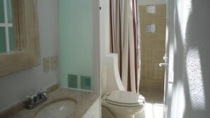 A bathroom with a sink, toilet, and shower curtain.