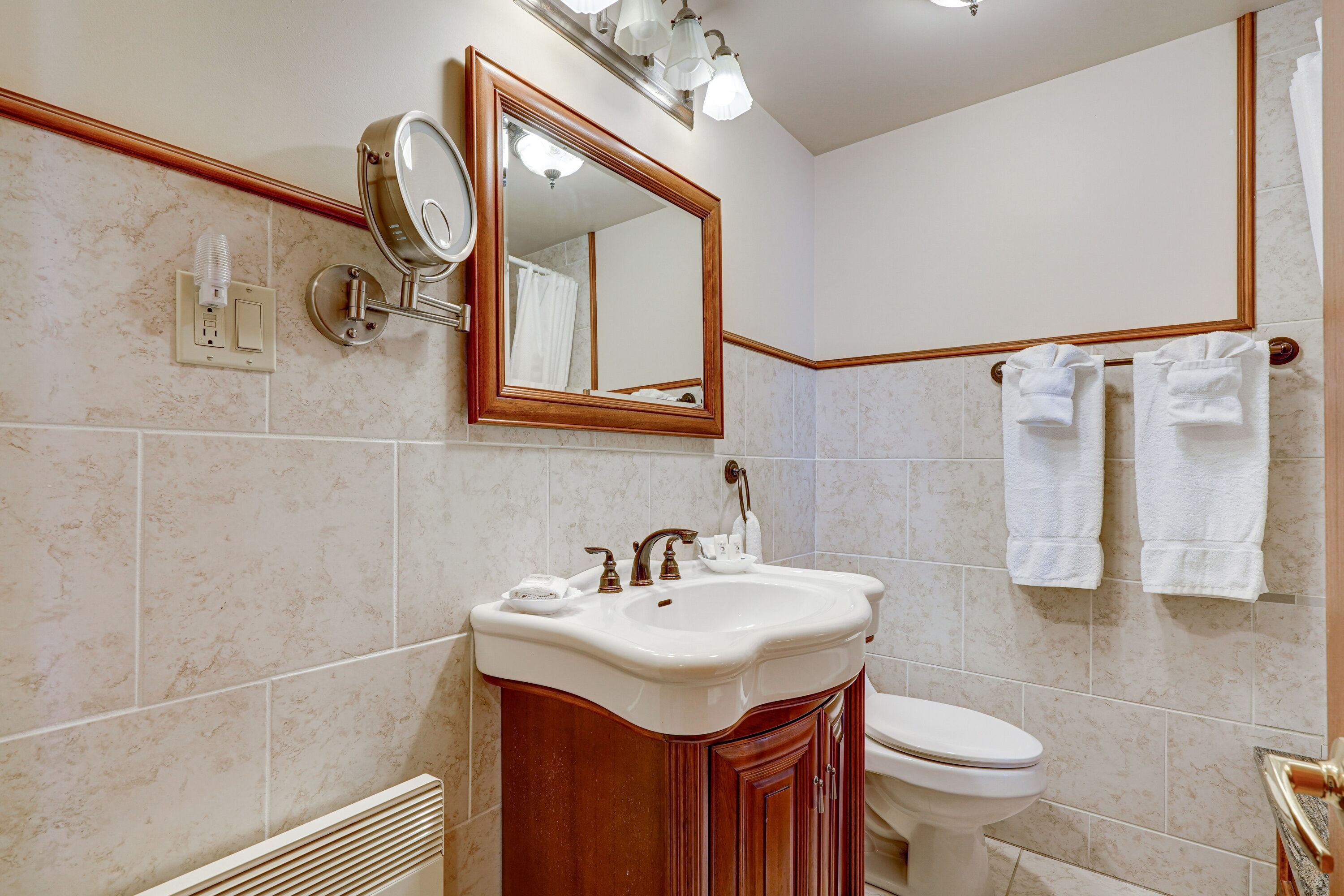 A bathroom with a sink, mirror, and towel rack.
