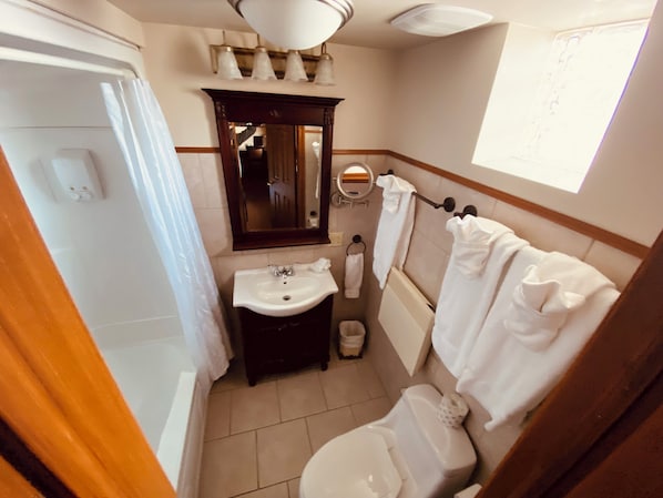 Un baño con bañera, lavabo, inodoro y espejo.
