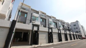 A modern multi-story residential building with balconies, large windows, and a clean facade. - Anping 72 Hostel (Tainan)