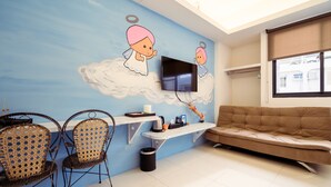A living room with a TV, sofa, and two wicker chairs. - Anping 72 Hostel (Tainan)