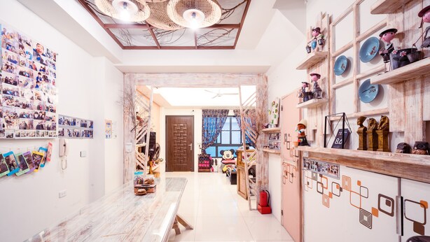 A spacious room with a long wooden table, a large photo collage on the wall, and shelves with various items. - Anping 72 Hostel (Tainan)