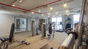 A gym with various exercise equipment, a treadmill, and a mirrored wall. - Pelicanstay in Coconut Grove Miami (Miami)