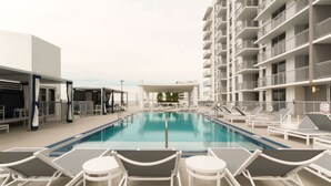 A swimming pool with lounge chairs and a covered seating area. - Pelicanstay in Coconut Grove Miami (Miami)