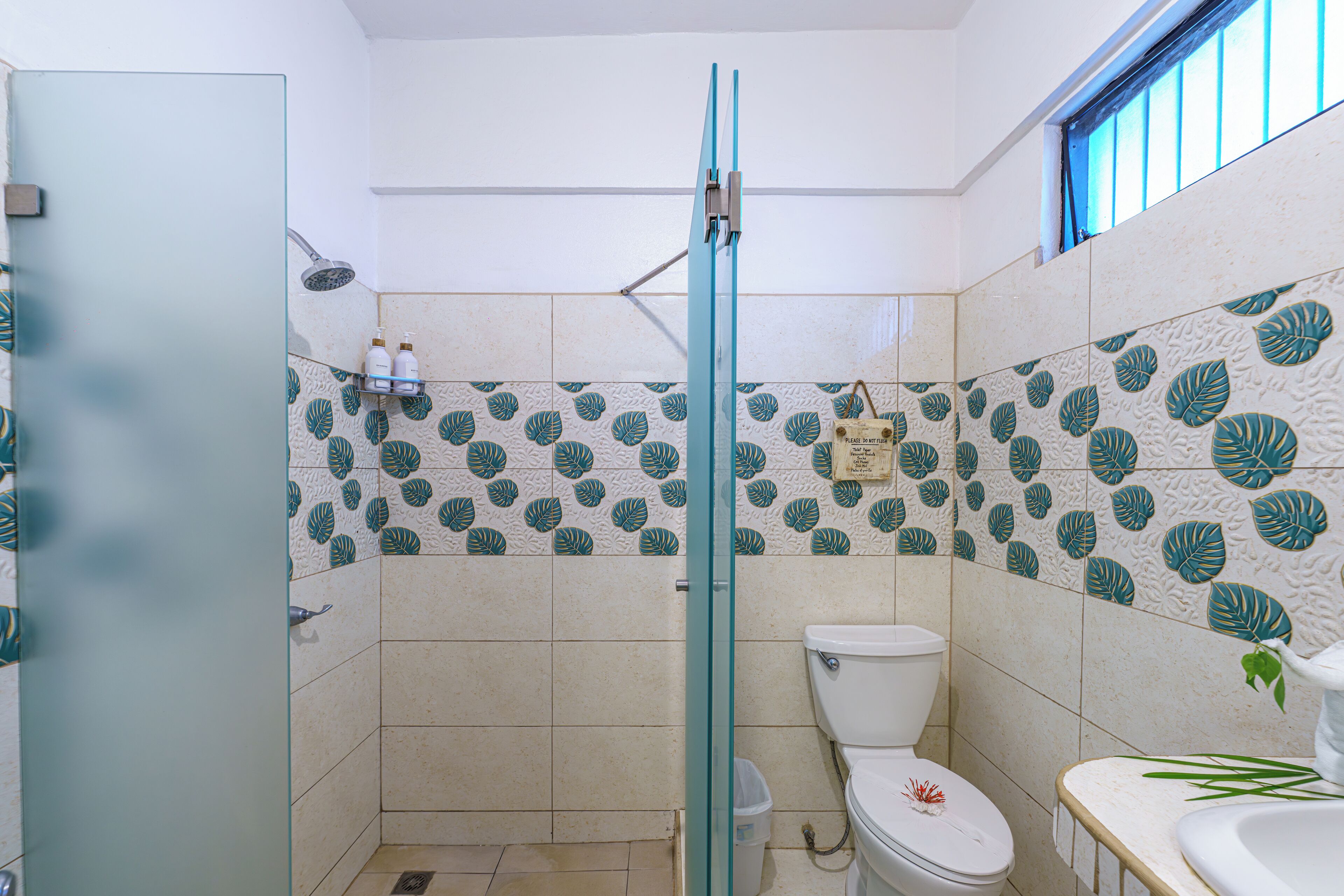 A bathroom with a shower, toilet, and sink.