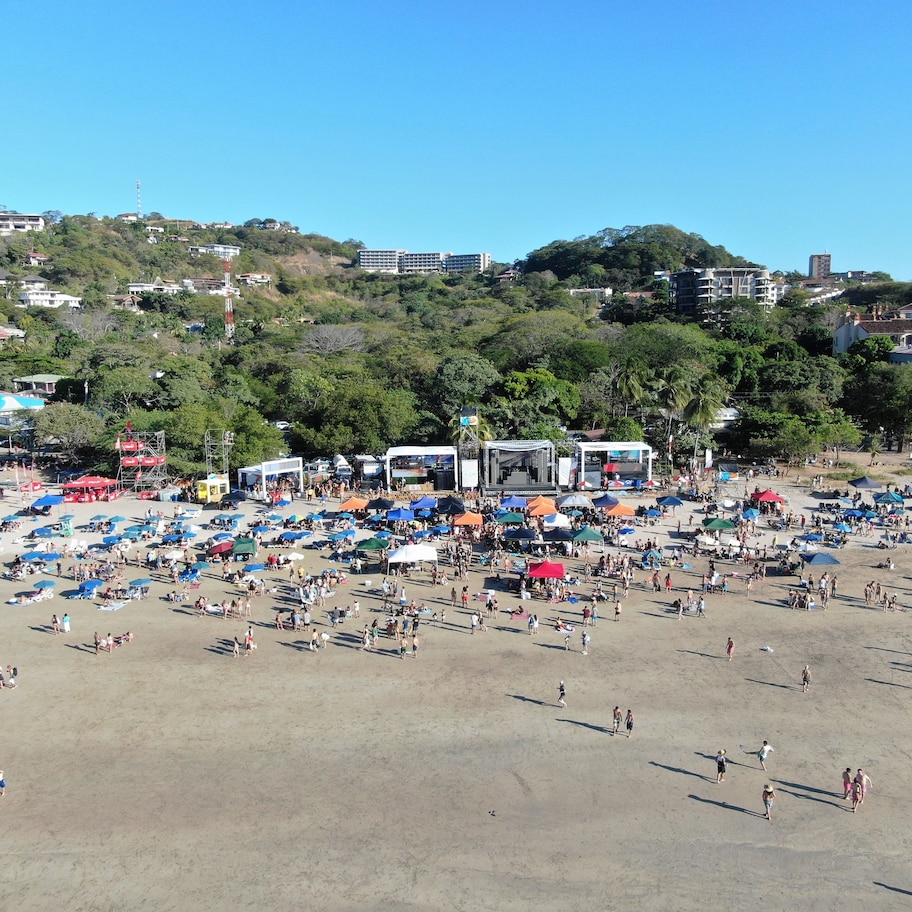 A beach with numerous umbrellas and people.