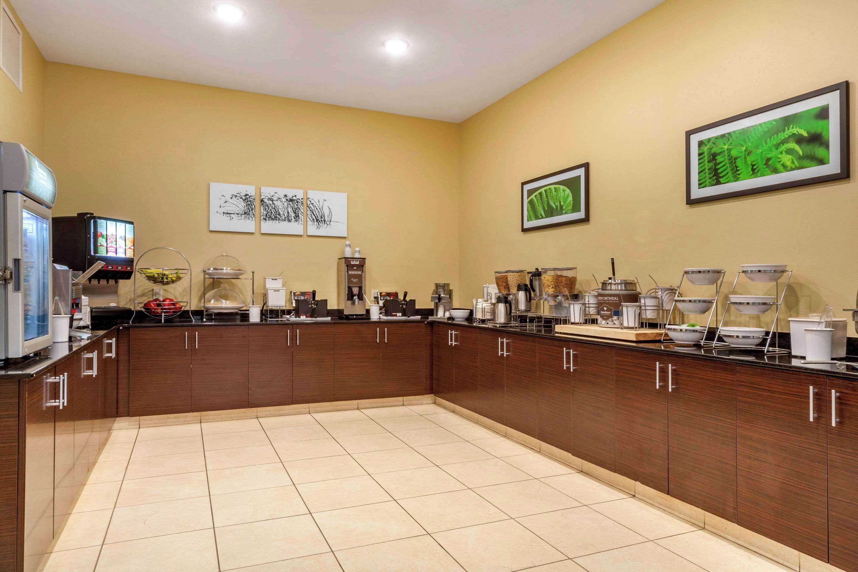 A spacious kitchen with a long counter, equipped with various appliances and a coffee station.