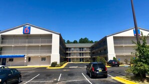 A 6-story motel with a central entrance and a parking lot. - Motel 6 Augusta, GA - Fort Gordon (Augusta)