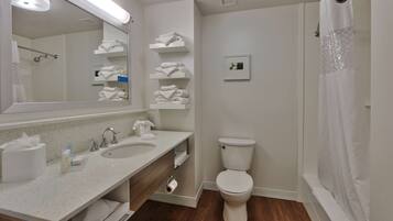 Et moderne badeværelse med dobbelt håndvaskebord, toilet og bruseområde.