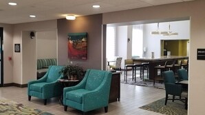 A lobby with teal armchairs, a coffee bar, and a dining area. - Hampton Inn & Suites Las Cruces I-10 (Las Cruces)