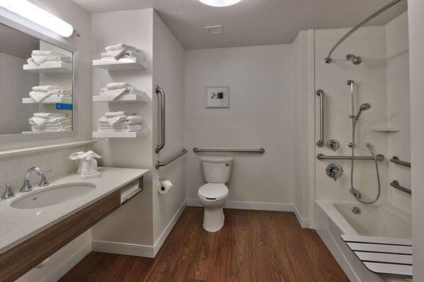 Un baño moderno con lavamanos, inodoro y ducha.