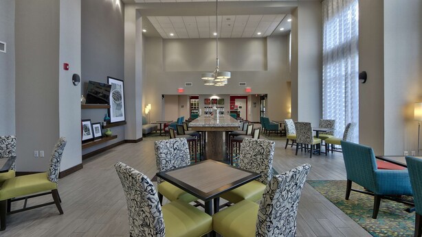 A spacious lobby with a central dining area, multiple seating options, and a modern chandelier. - Hampton Inn & Suites Las Cruces I-10 (Las Cruces)