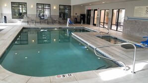 An indoor swimming pool with clear water, tiled edges, and a metal safety railing. - Hampton Inn & Suites Las Cruces I-10 (Las Cruces)