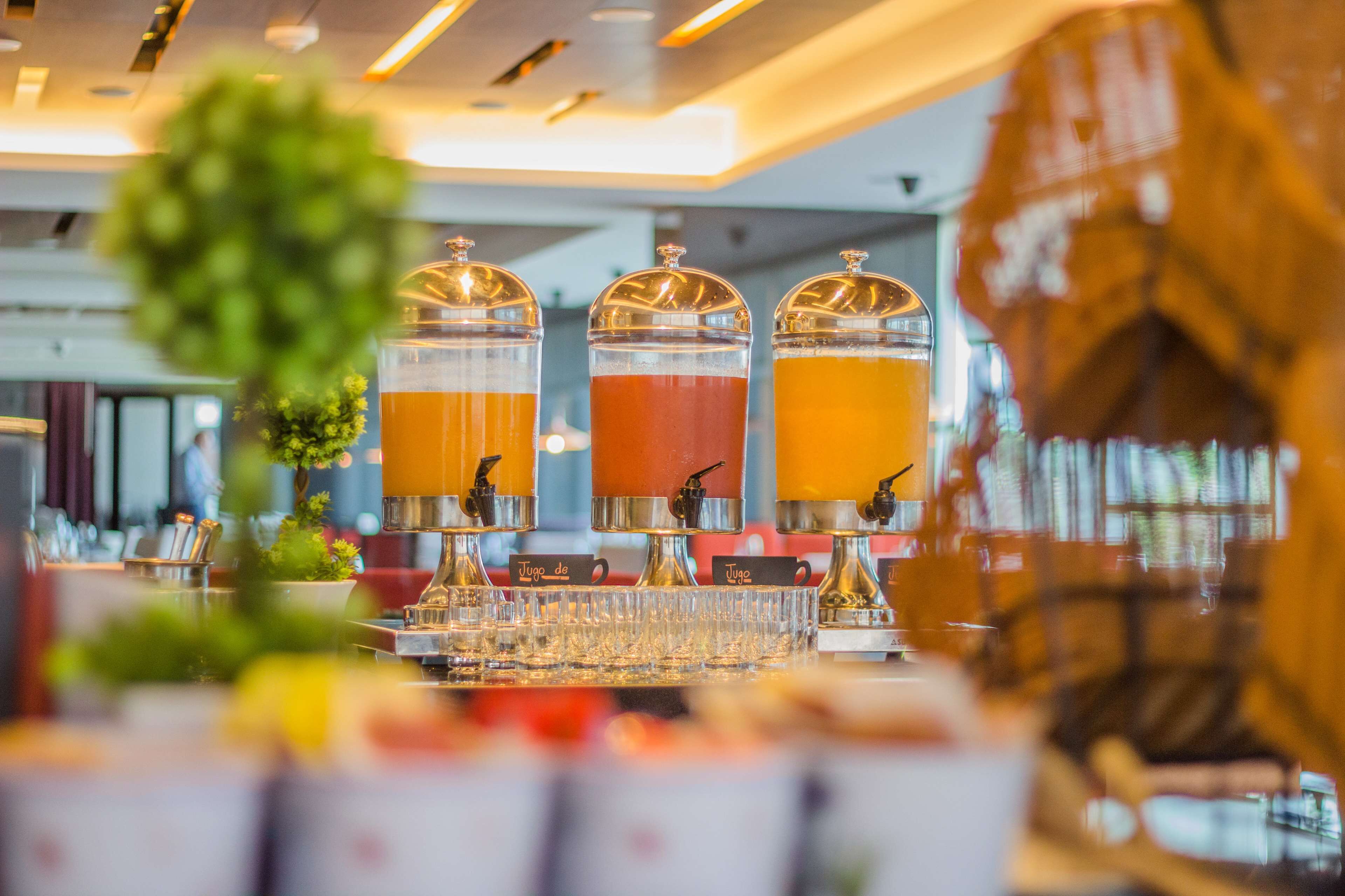 A buffet setup with three beverage dispensers, each labeled with a different drink name.