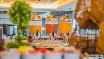 A buffet setup with three beverage dispensers, each labeled with a different drink name.