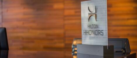 A reception desk with a sign reading "Hilton HONORS".