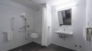 A modern bathroom with a shower, toilet, and sink.