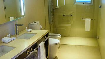A modern bathroom with a glass-enclosed shower, a large mirror, and a dual sink vanity.