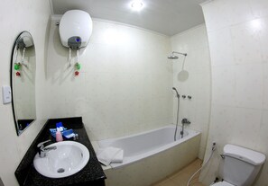 A bathroom with a sink, mirror, hand dryer, and a bathtub. - Hotel Glory (Yangon)