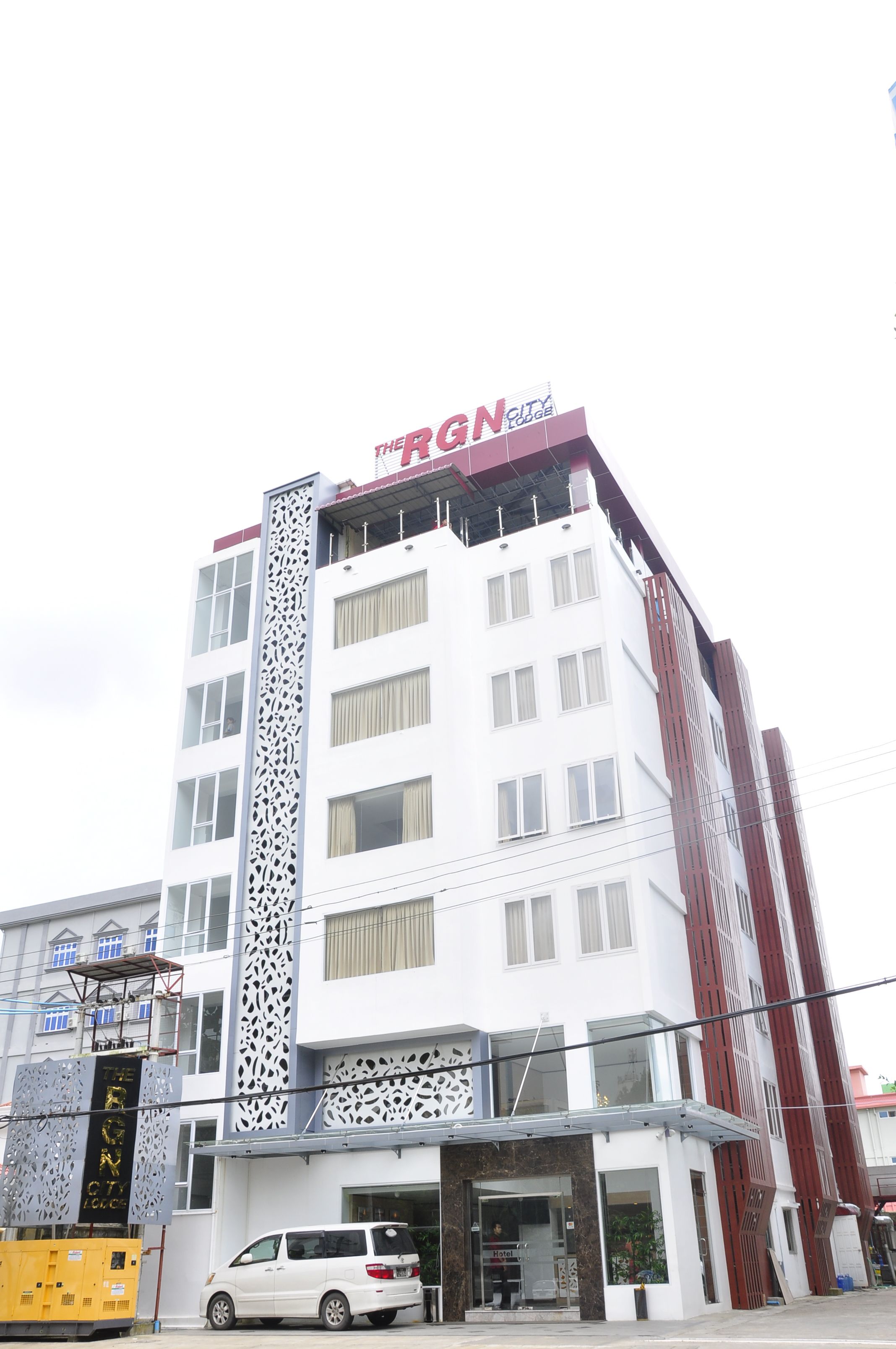 Un hotel de varios pisos con un letrero llamativo que dice "BGN City Lodge".