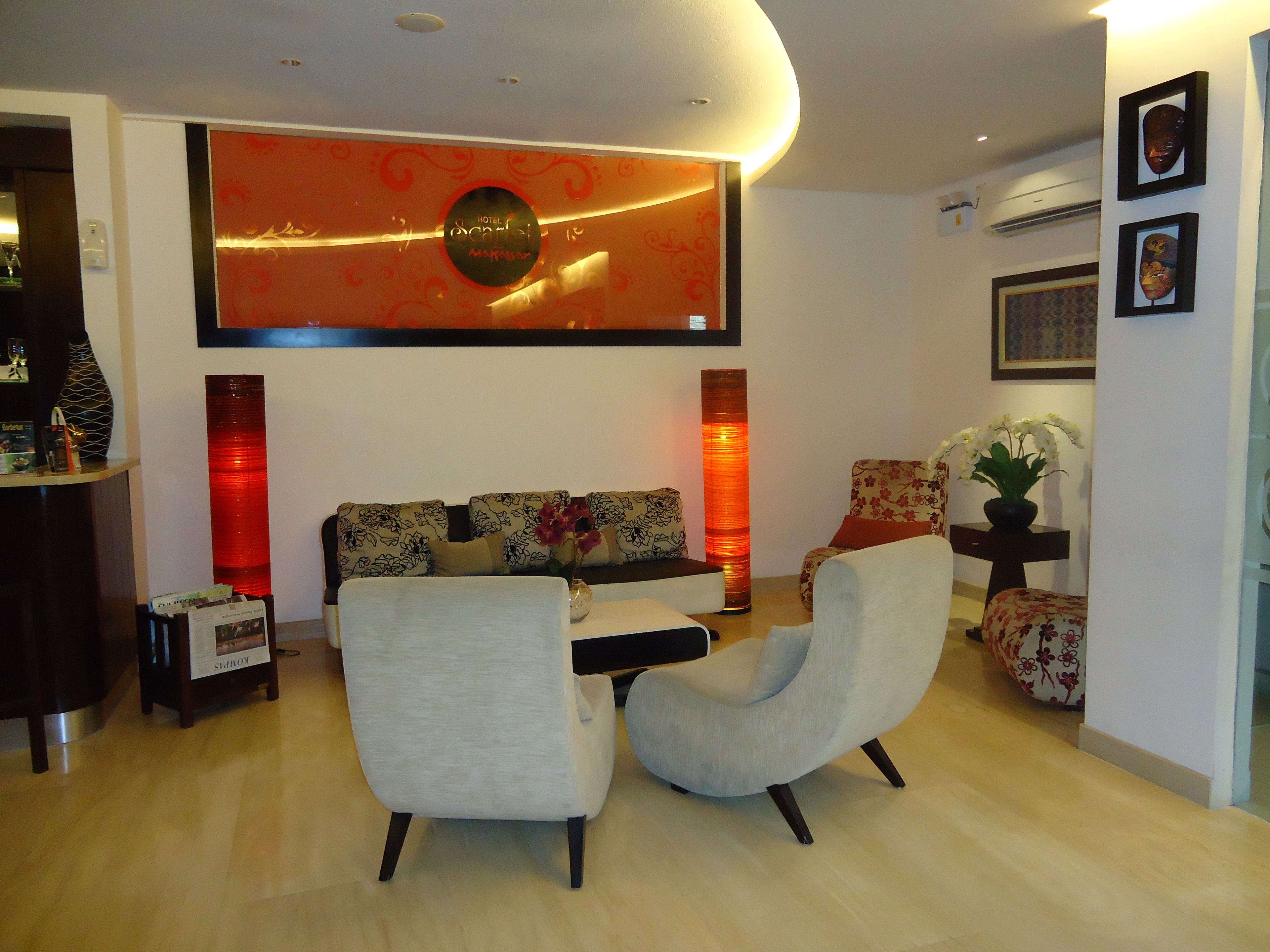 A modern living room with a sofa set, two armchairs, a coffee table, and a decorative wall piece.