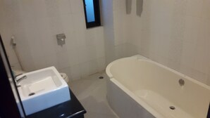 Un baño con bañera, inodoro y lavamanos.