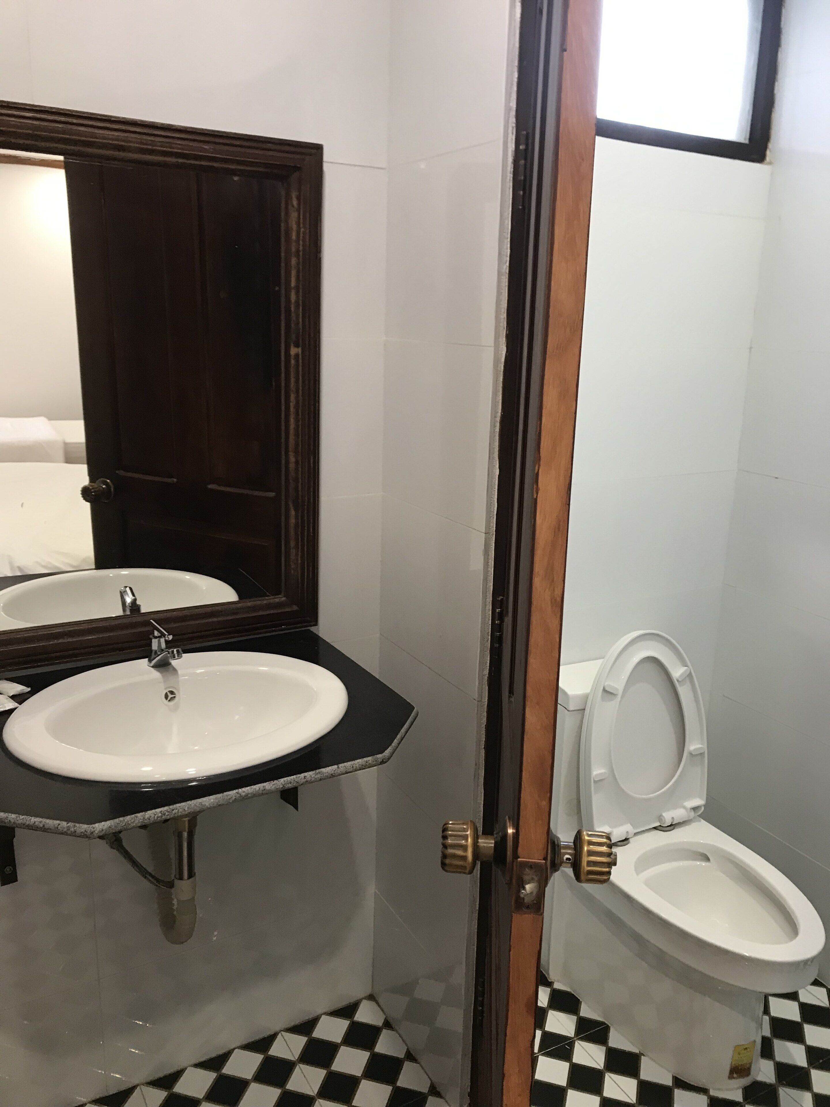 Un baño con lavamanos, espejo y retrete.