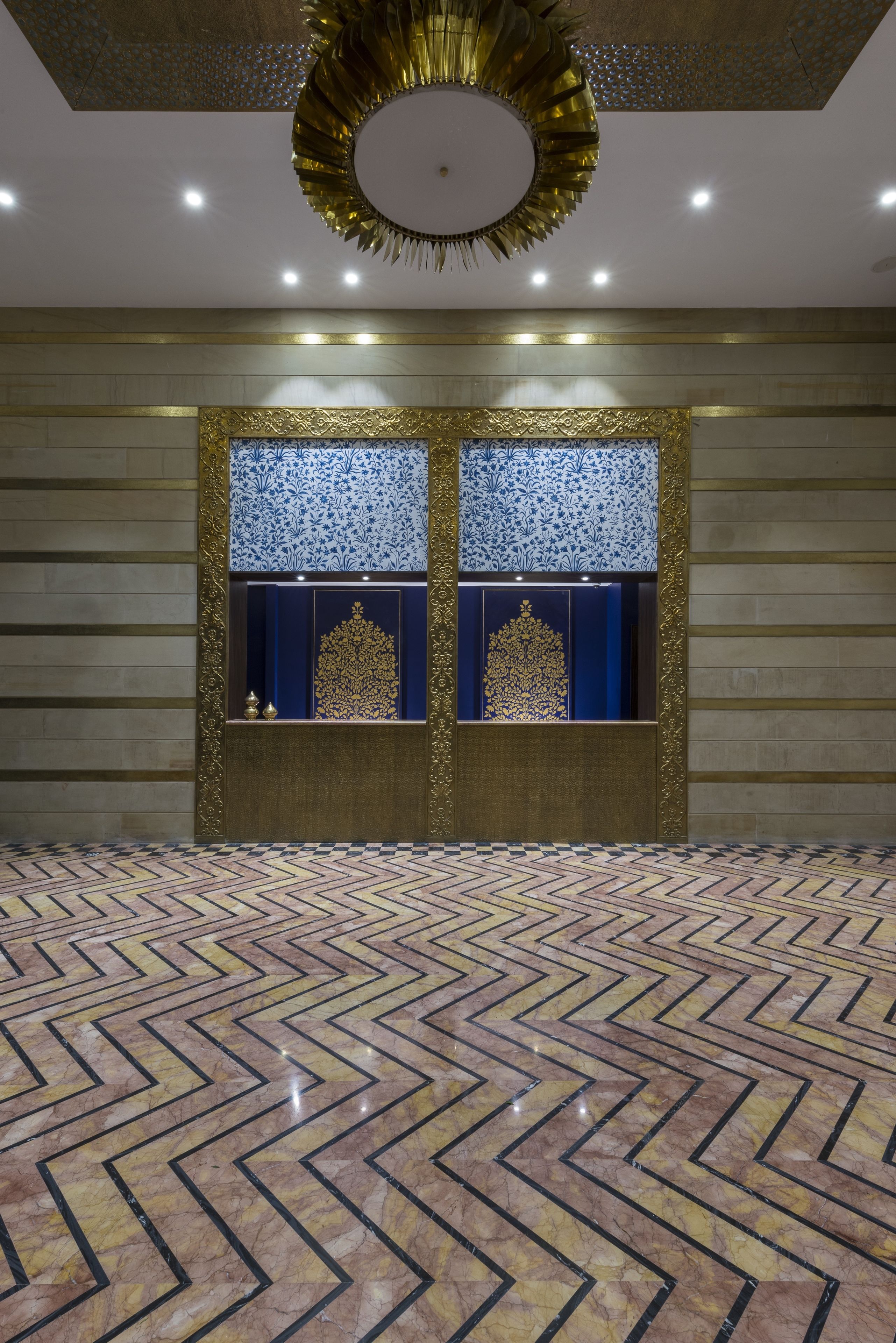A spacious room with a patterned floor, a decorative ceiling, and two illuminated display cases.