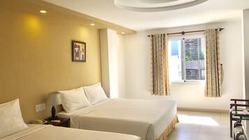 A hotel room with two beds, a desk, a chair, a window with curtains, a ceiling light, and a wall-mounted picture.