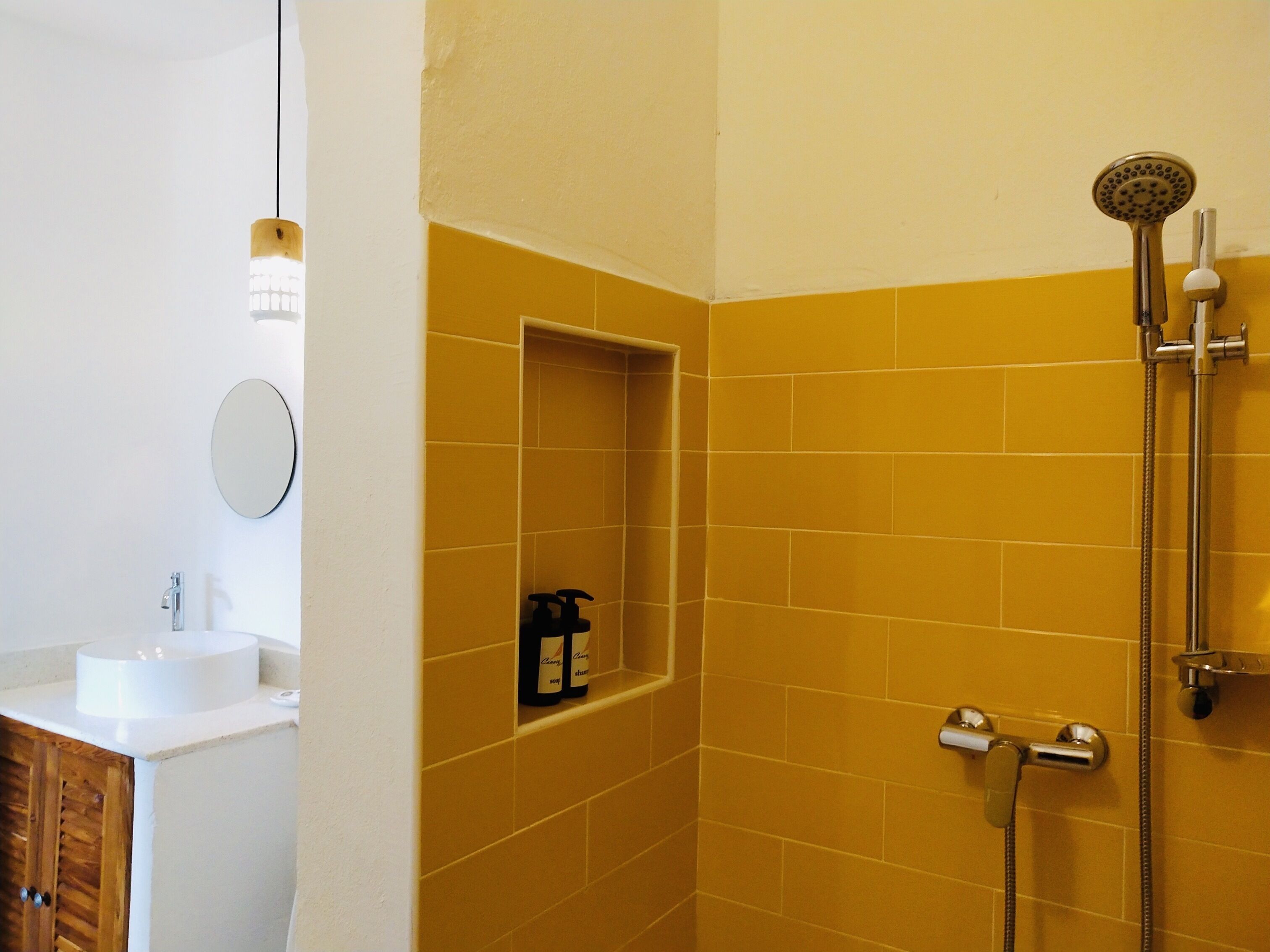 Un baño con ducha, lavabo y espejo.