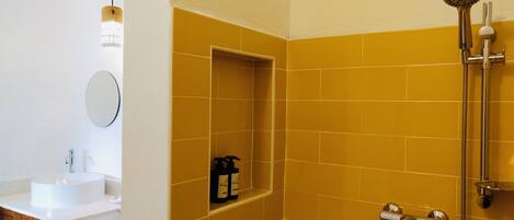 Un baño con ducha, lavabo y espejo.