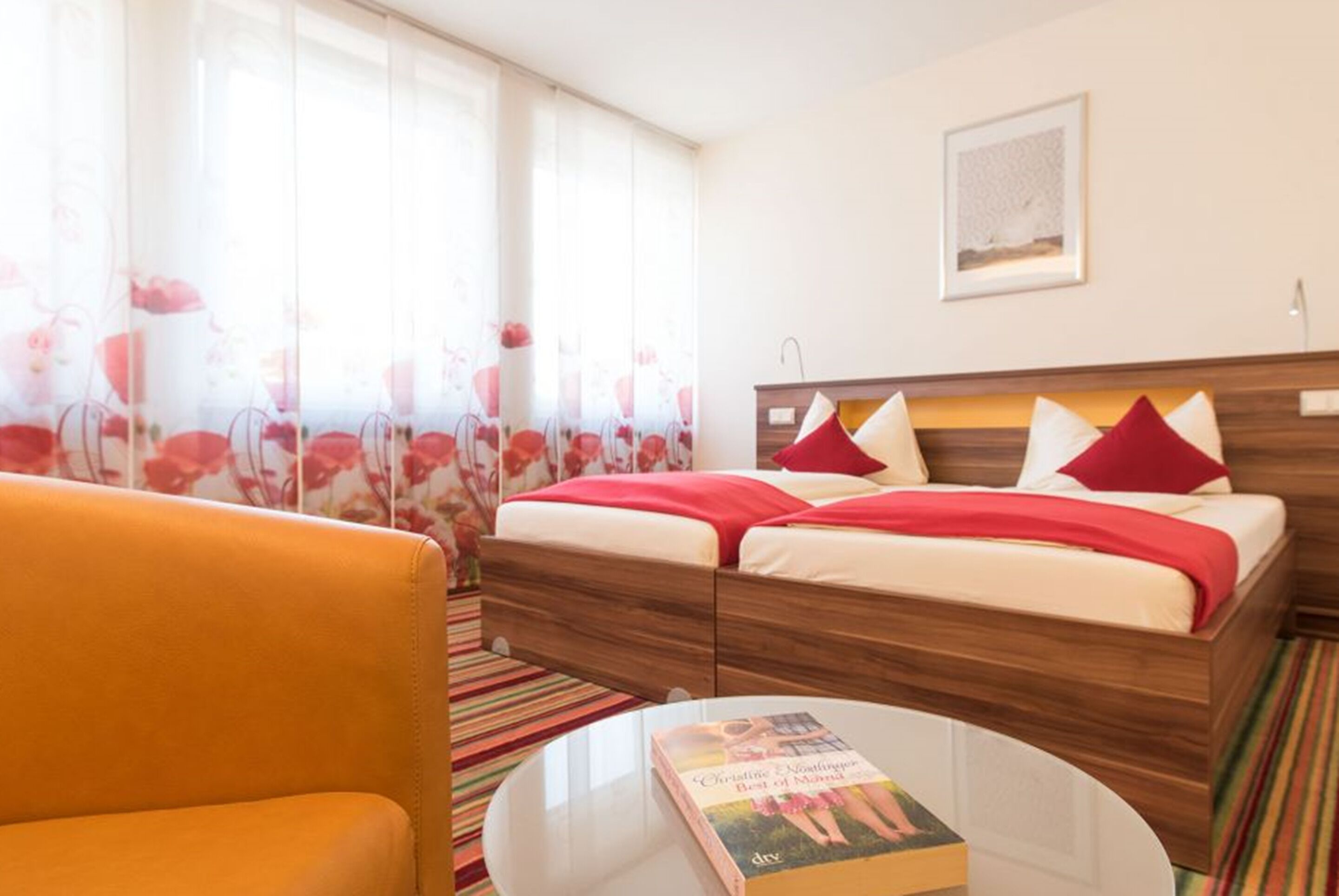 A hotel room with a bed, a sofa, and a coffee table.