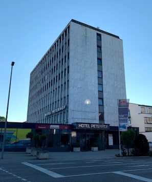 A modern hotel building with a prominent sign reading "HOTEL PETERHOF". - Hotel Peterhof (Kempten)